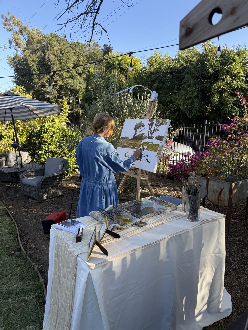 A live painter working at an easel in the garden