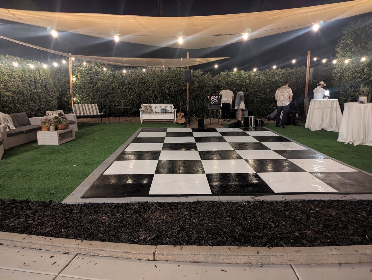 Il Prato at night with the checkered dance floor, band setup, and lounge furniture