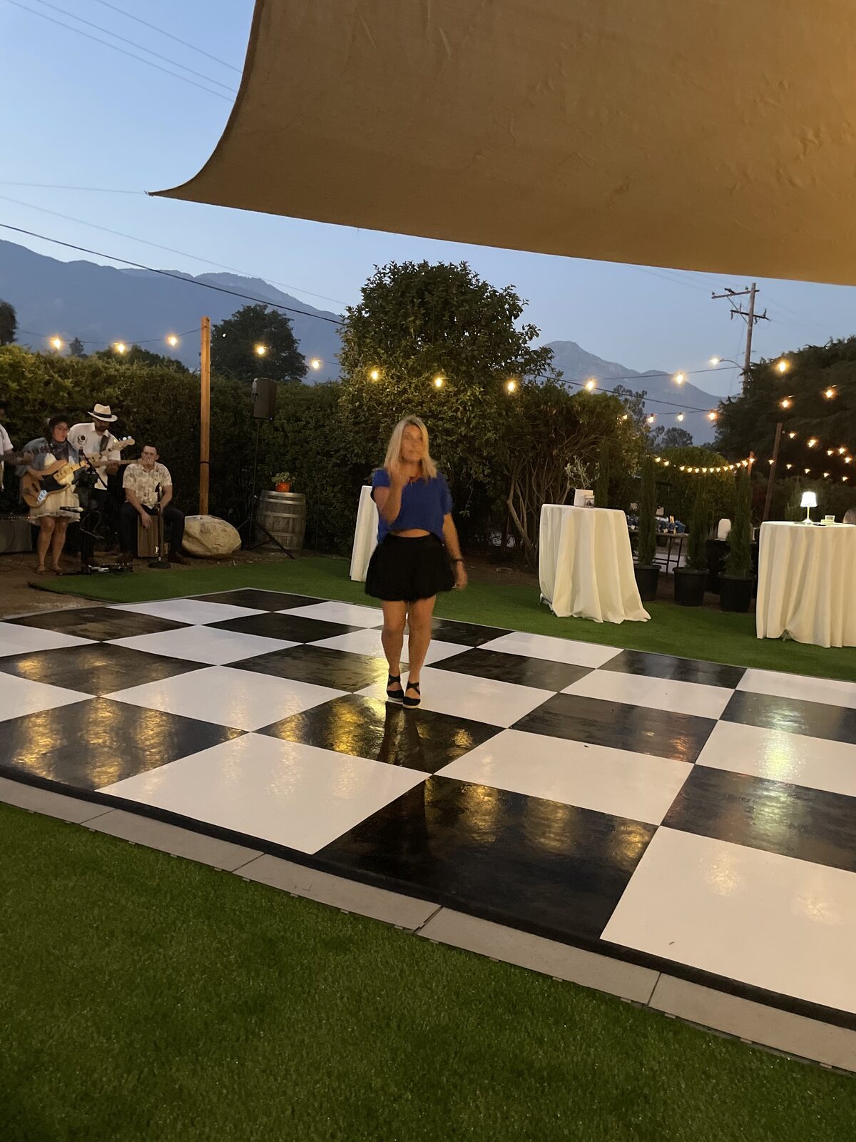 Live band playing beside the checkered dance floor on Il Prato, mountains in the distance