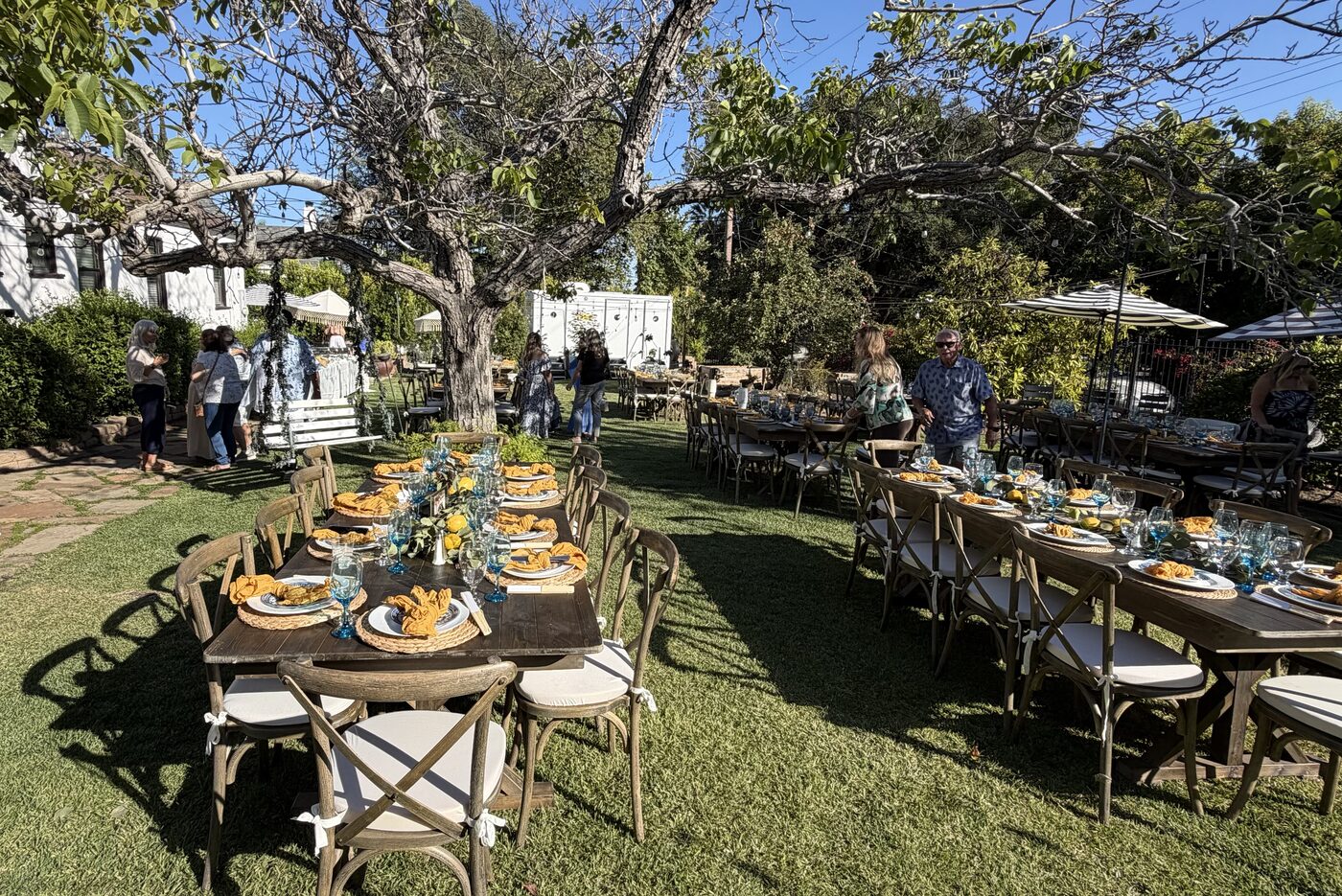 Multiple long dining tables fully set on Il Giardino, the real grass dining lawn