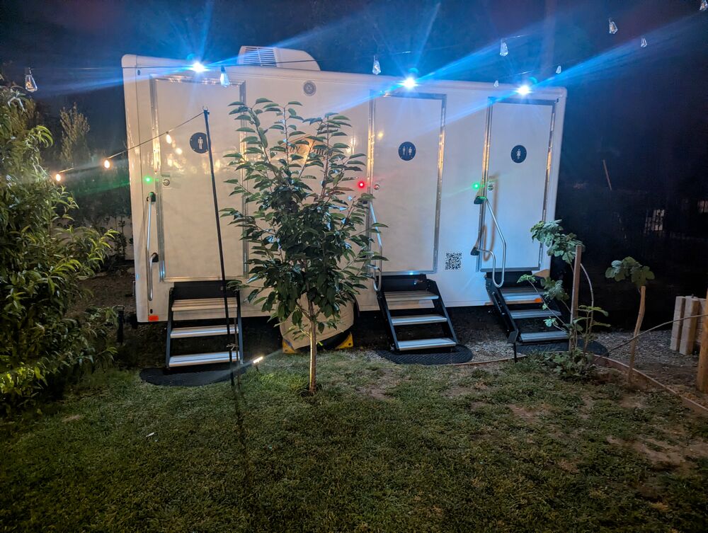 Portable restroom trailer set up in the garden at night