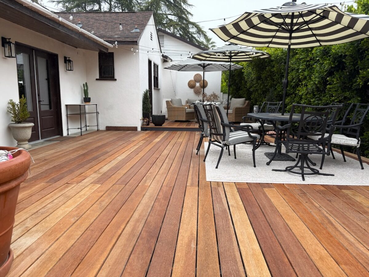 The Brazilian hardwood deck with outdoor dining table and umbrellas
