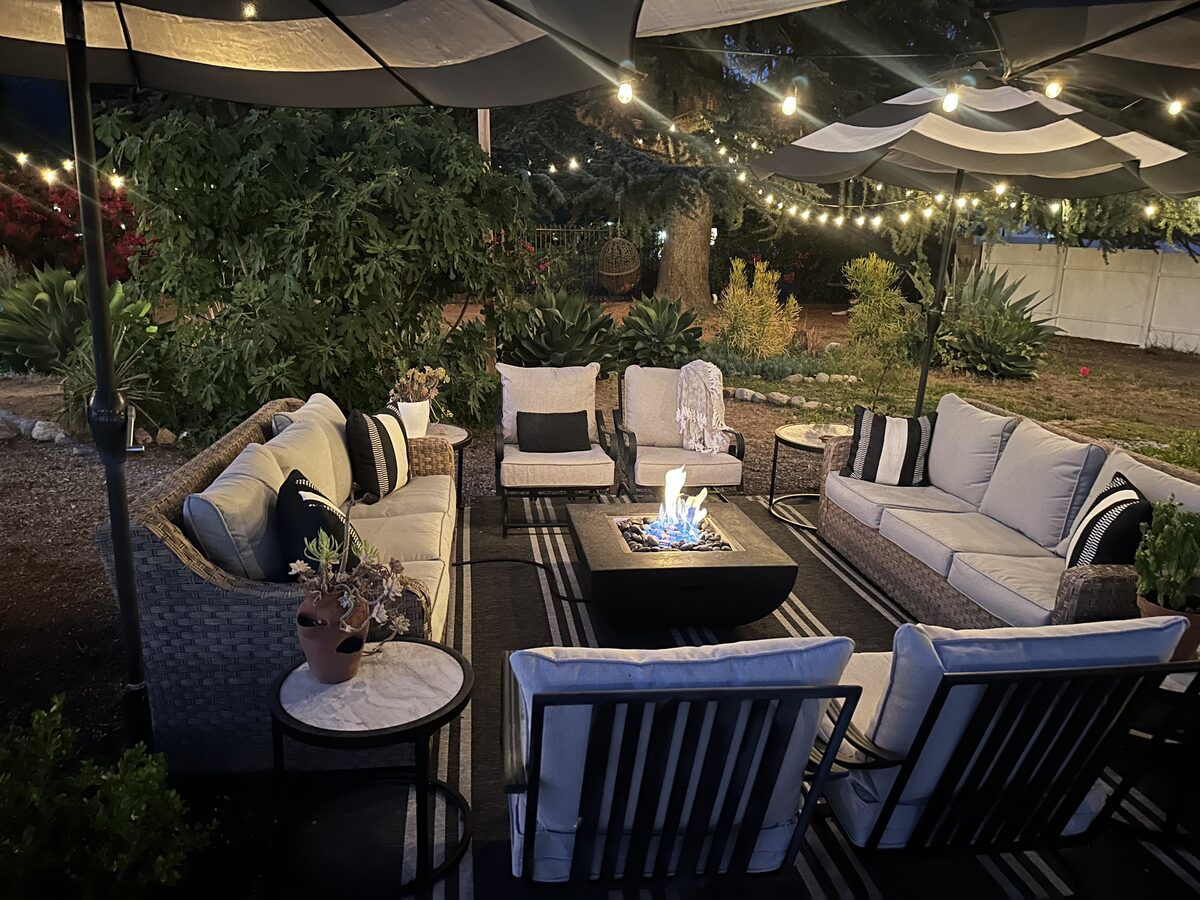 The firepit lounge with couches and chairs, string lights above